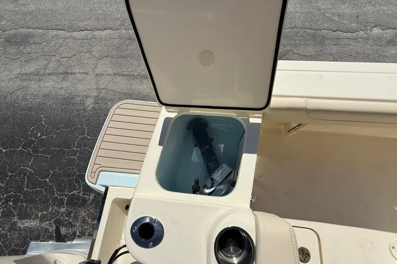 Slide: The Image of Open storage compartment on 2026 Scout 220 XSF boat, showing interior and accessories. - 8
