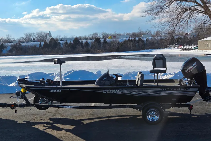The Image of 2021 Lowe Stinger 175C boat on trailer by snowy lake, clear sky. - 0