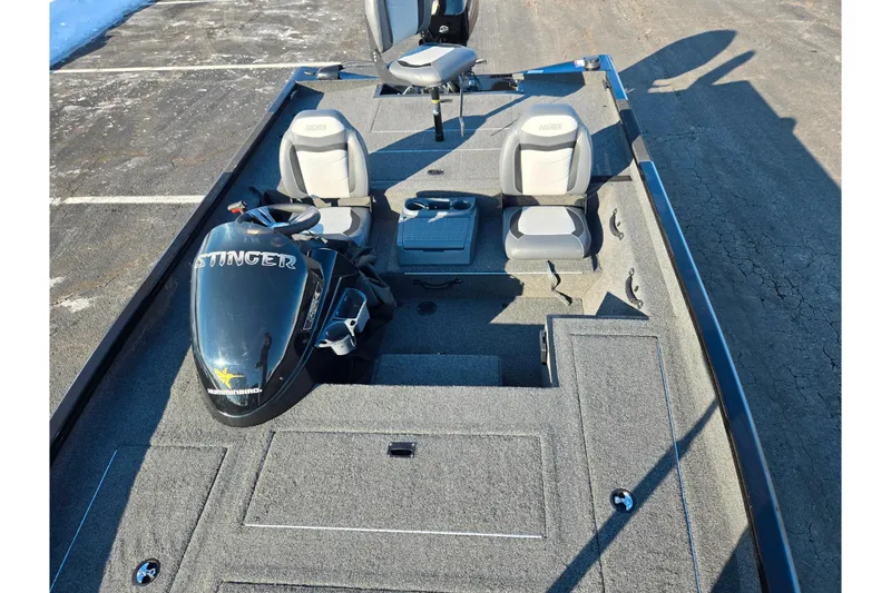 Slide: The Image of 2021 Lowe Stinger 175C fishing boat interior with seats and motor, parked on asphalt. - 18
