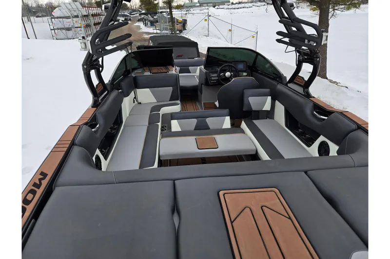 Slide: The Image of 2021 Moomba Max boat interior with modern seating and dashboard, set in a snowy landscape. - 10