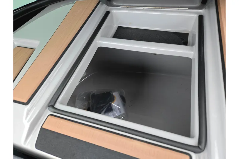 Slide: The Image of 2021 Moomba Max storage compartment with wood accents and spacious interior. - 16