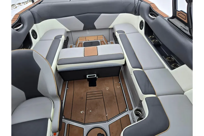 Slide: The Image of 2021 Moomba Max boat interior with gray and white seating, cup holders, and teak flooring. - 24