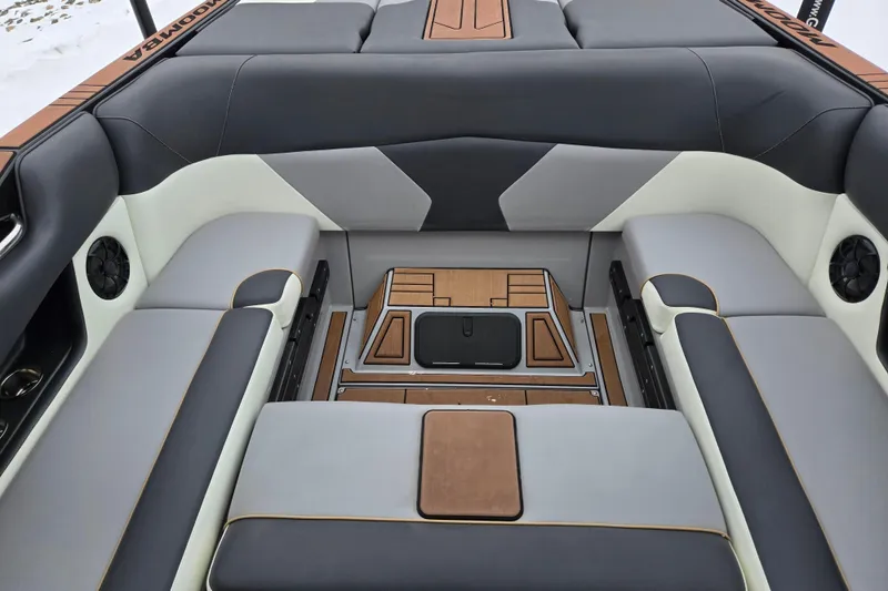 Slide: The Image of 2021 Moomba Max boat interior with gray and white seating and wood accents. - 25
