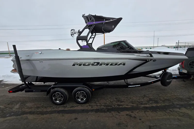 Slide: The Image of 2021 Moomba Max boat on trailer, side view, parked on snowy pavement. - 4