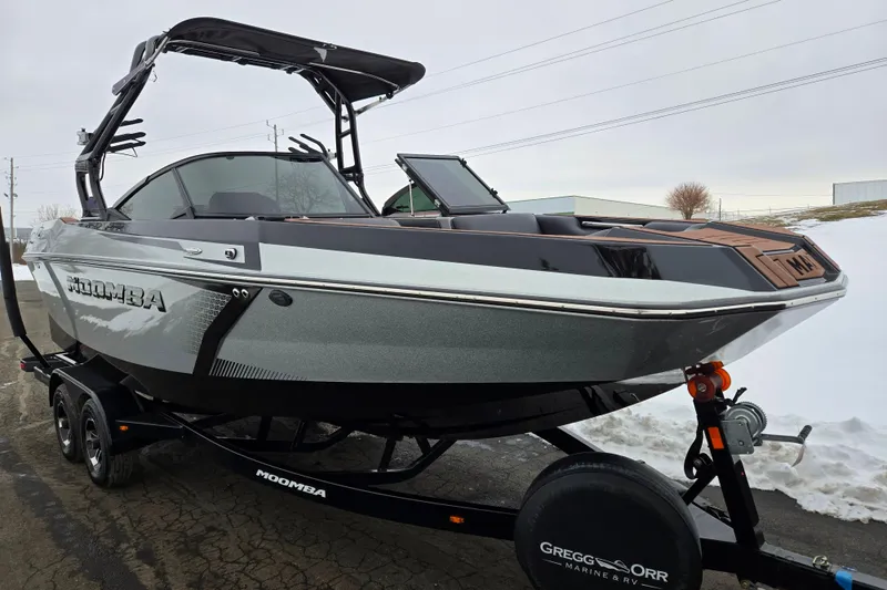 Slide: The Image of 2021 Moomba Max boat on trailer, sleek design, parked on snowy pavement. - 5