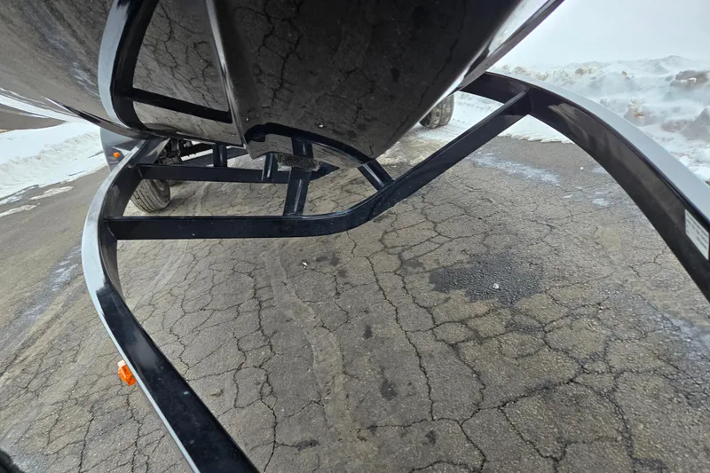 Slide: The Image of 2021 Moomba Max boat trailer on cracked pavement with snow in background. - 7