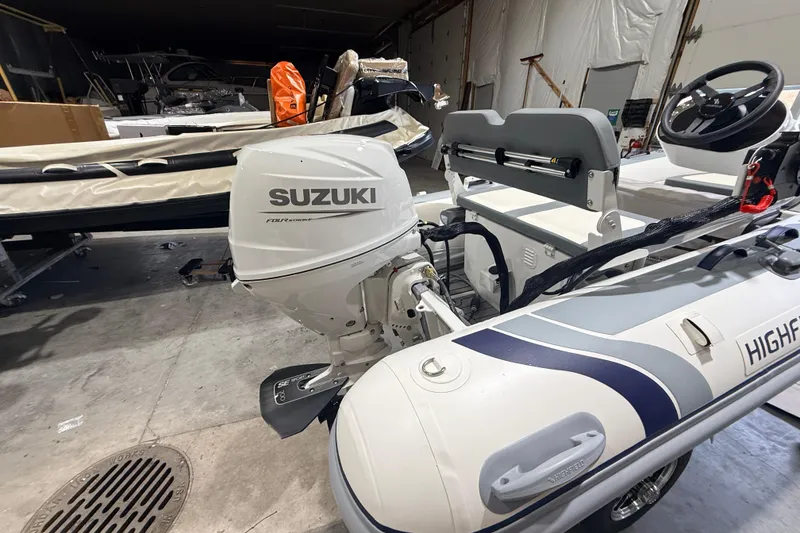 Slide: The Image of 2026 Highfield Classic 340 FCT with Suzuki outboard motor in a storage facility. - 4
