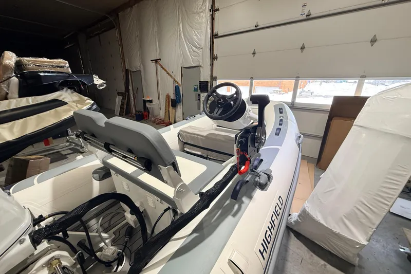 Slide: The Image of 2026 Highfield Classic 340 FCT boat in a garage, showcasing interior and steering console. - 5