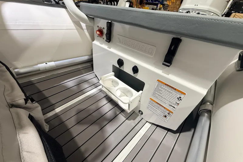 Slide: The Image of 2026 Highfield Classic 340 FCT boat interior with cup holders and safety instructions. - 6