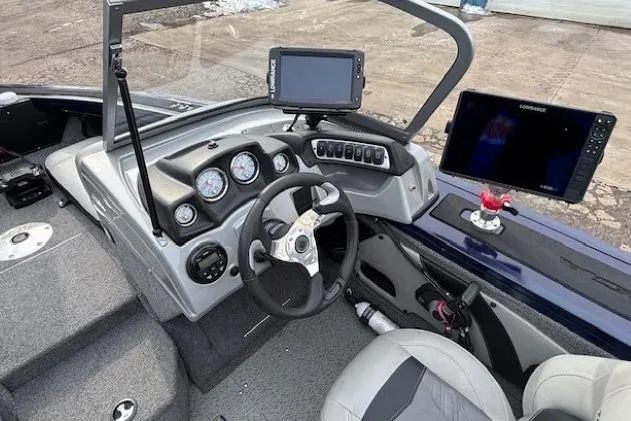 Slide: The Image of 2019 Tracker Targa V-18 Combo boat dashboard with steering wheel and navigation screens. - 16