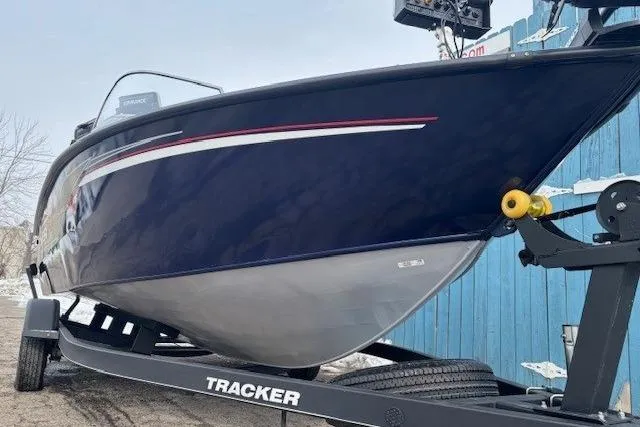 Slide: The Image of 2019 Tracker Targa V-18 Combo boat on trailer, blue hull, parked outdoors. - 2