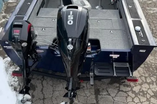 Slide: The Image of 2019 Tracker Targa V-18 Combo boat with dual outboard motors on a paved surface. - 40
