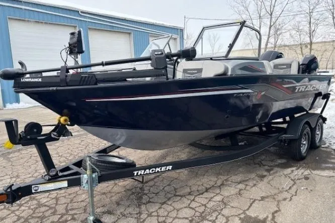 Slide: The Image of 2019 Tracker Targa V-18 Combo boat on trailer, parked outside a blue building. - 5