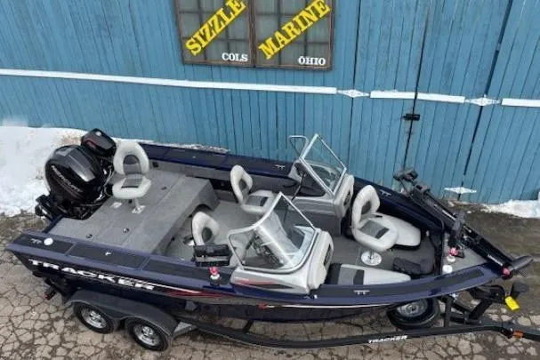 Slide: The Image of 2019 Tracker Targa V-18 Combo boat parked near blue building, Sizzle Marine sign visible. - 7