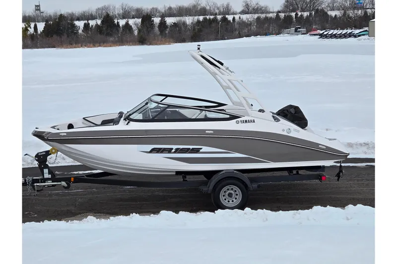 The Image of 2023 Yamaha Boats AR195 on trailer in snowy landscape. - 0
