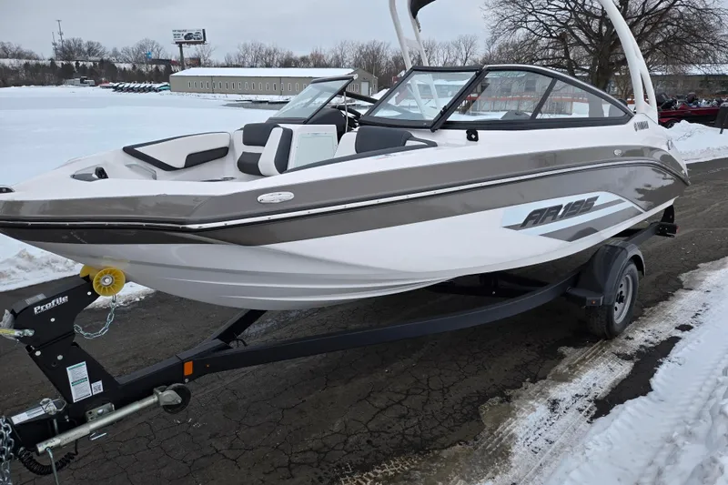Slide: The Image of 2023 Yamaha Boats AR195 on trailer, sleek design, parked on snowy pavement. - 8