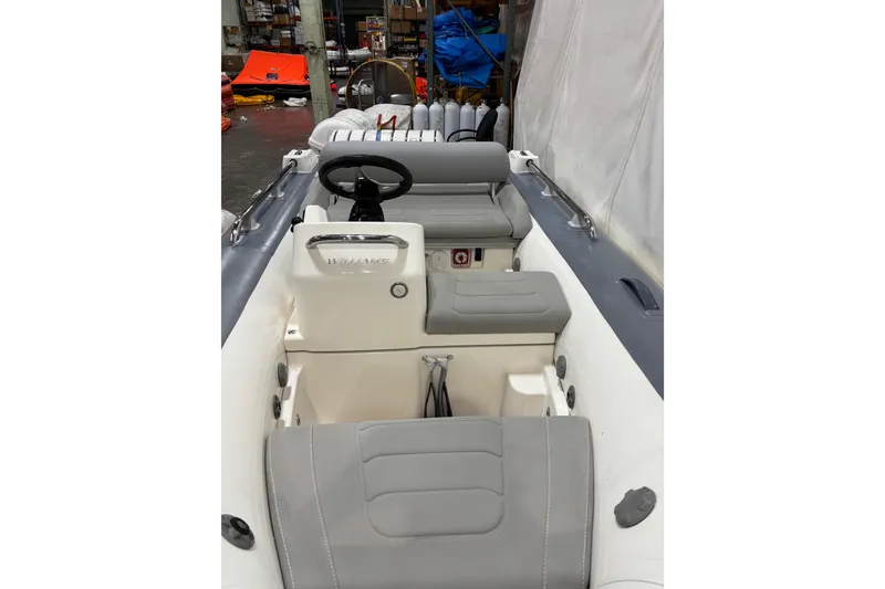 Slide: The Image of 2021 Williams Jet Tenders Sportjet 345 interior with gray seating and steering wheel. - 5