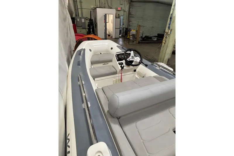 Slide: The Image of 2021 Williams Jet Tenders Sportjet 345 with gray seating in a warehouse setting. - 7