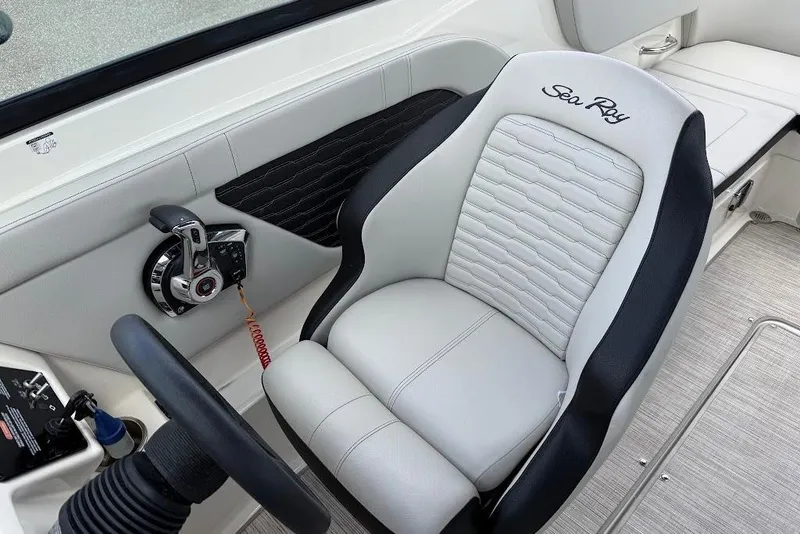 Slide: The Image of 2023 Sea Ray SPX 230 boat interior with steering wheel and branded seat. - 14