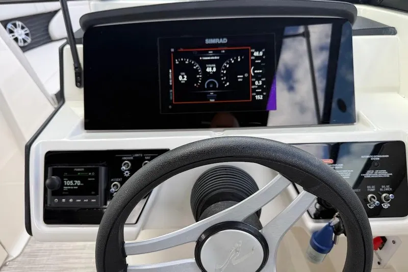 Slide: The Image of 2023 Sea Ray SPX 230 dashboard with steering wheel and digital display. - 16
