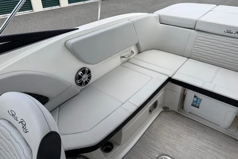 Slide: The Image of 2023 Sea Ray SPX 230 boat interior with white cushioned seating and storage. - 20