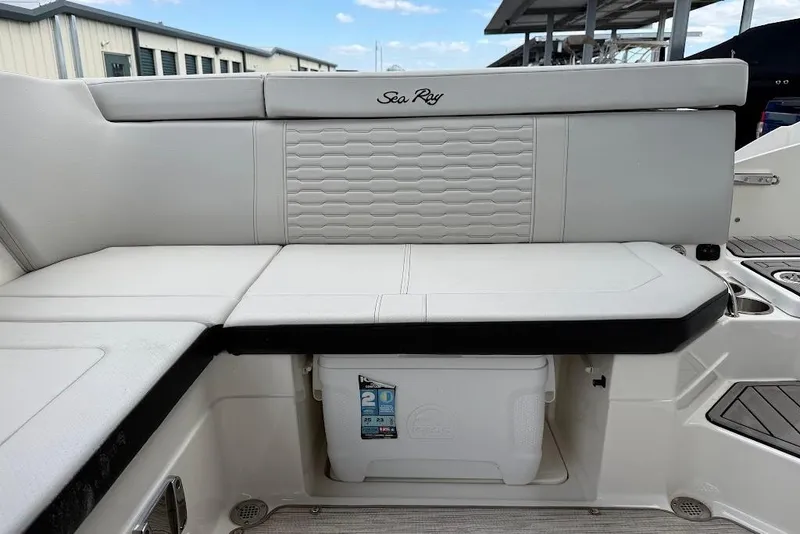 Slide: The Image of 2023 Sea Ray SPX 230 boat seating area with storage compartment and cooler. - 21