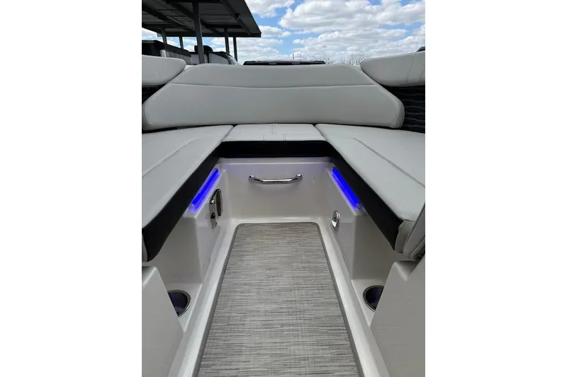 Slide: The Image of 2023 Sea Ray SPX 230 boat interior with cushioned seating and blue LED lighting. - 26