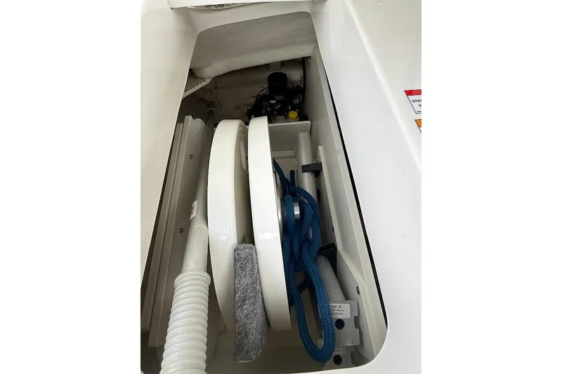 Slide: The Image of Storage compartment in 2023 Sea Ray SPX 230 boat with coiled rope and equipment. - 29