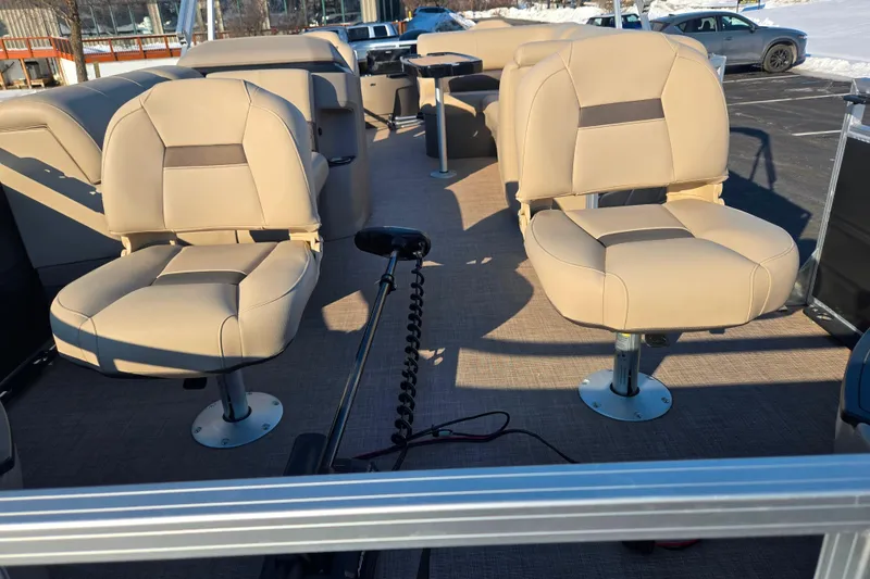 Slide: The Image of 2024 Sun Tracker Fishin' Barge 20 DLX interior with beige seating and fishing setup. - 10