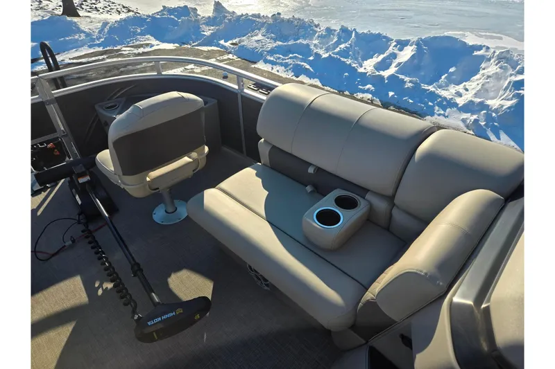 Slide: The Image of 2024 Sun Tracker Fishin' Barge 20 DLX interior with seating and snow background. - 21