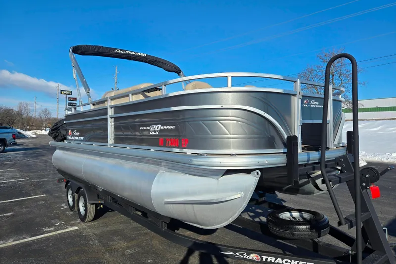 Slide: The Image of 2024 Sun Tracker Fishin' Barge 20 DLX pontoon boat on trailer in parking lot. - 5