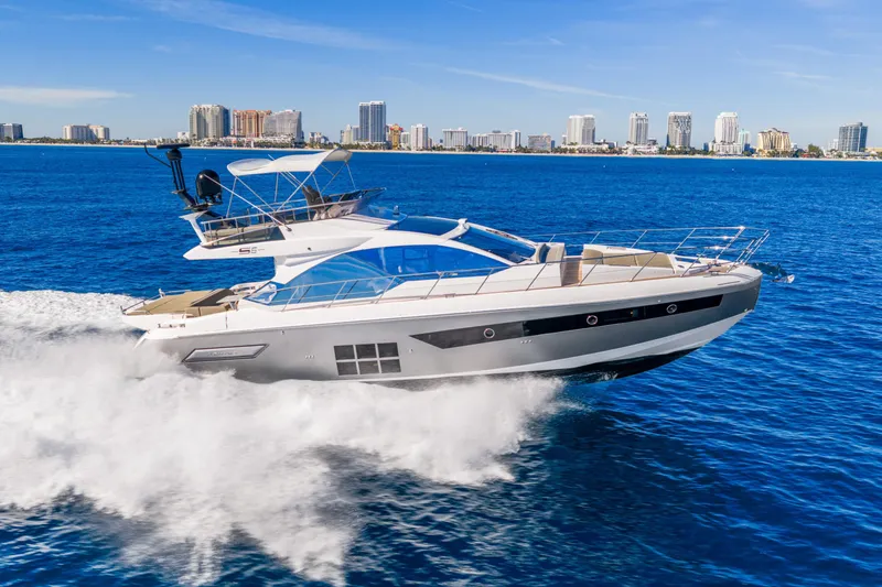 The Image of 2021 Azimut S6 yacht cruising on blue ocean near city skyline. - 0