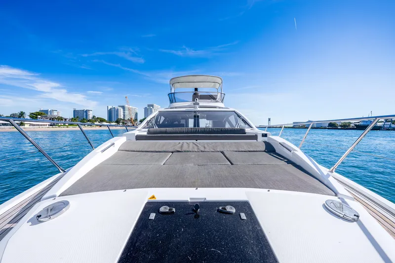 Slide: The Image of 2021 Azimut S6 yacht on water, city skyline in background, clear blue sky. - 37