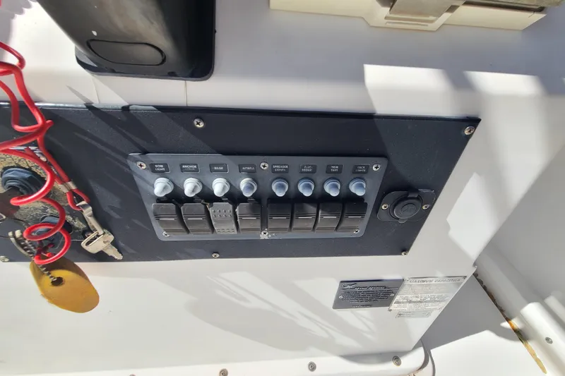 Slide: The Image of Control panel of a 1995 Mako 201 Center Console boat with switches and keys. - 11