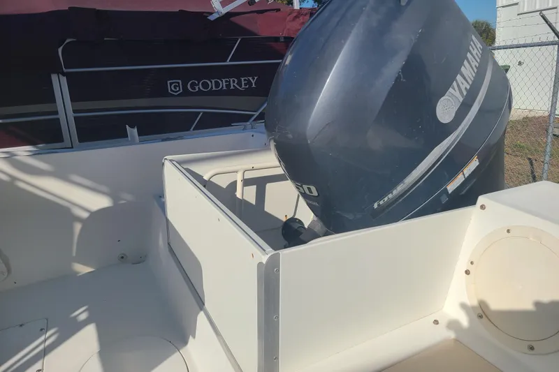 Slide: The Image of 1995 Mako 201 Center Console boat with Yamaha outboard motor, docked near Godfrey boat. - 14
