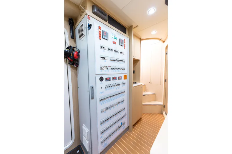 Slide: The Image of Electrical control panel inside 2014 Riva 86' DOMINO yacht, featuring modern equipment and wooden flooring. - 59
