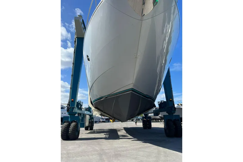 Slide: The Image of 2014 Riva 86' DOMINO yacht in dry dock, viewed from below, with blue sky background. - 83