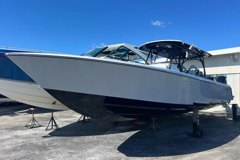 The Image of 2026 Contender 39 ST boat on stands, sleek design under clear blue sky. - 1