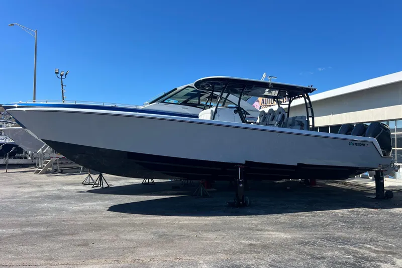 Slide: The Image of 2026 Contender 39 ST boat on display at a marina under clear blue sky. - 3