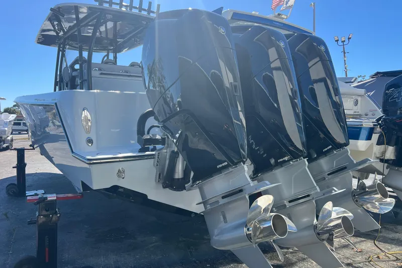 Slide: The Image of 2026 Contender 39 ST boat with powerful triple outboard engines, docked under clear blue sky. - 5