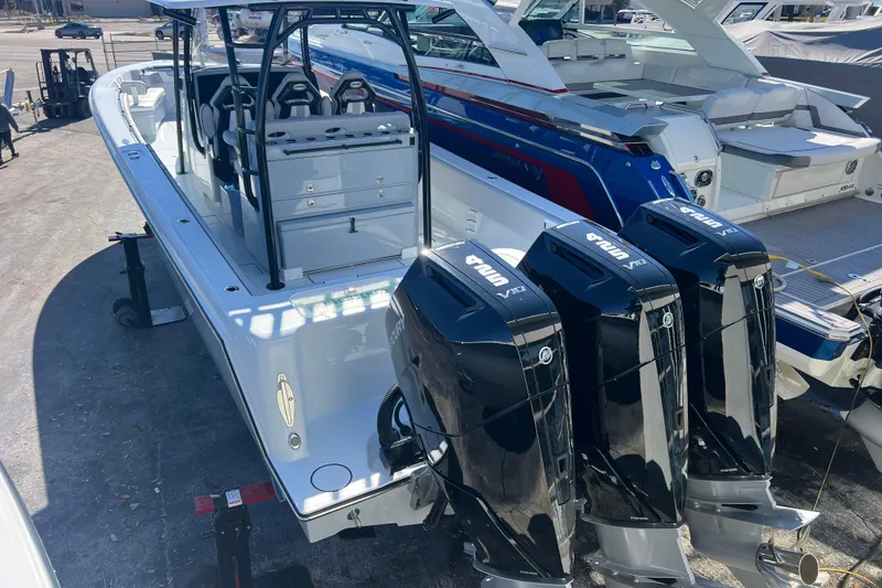 Slide: The Image of 2026 Contender 39 ST boat with triple outboard engines, docked alongside other vessels. - 7