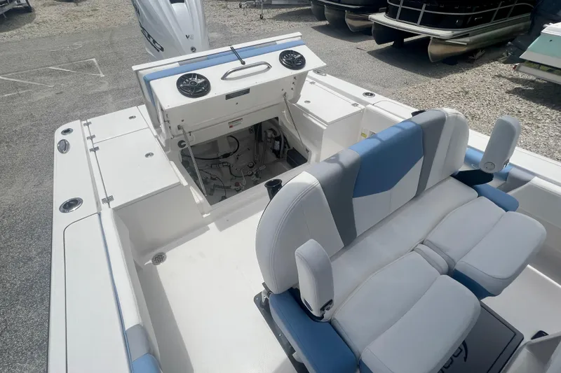 Slide: The Image of 2025 Robalo 266 Cayman SD boat interior with seating and open storage compartment. - 10