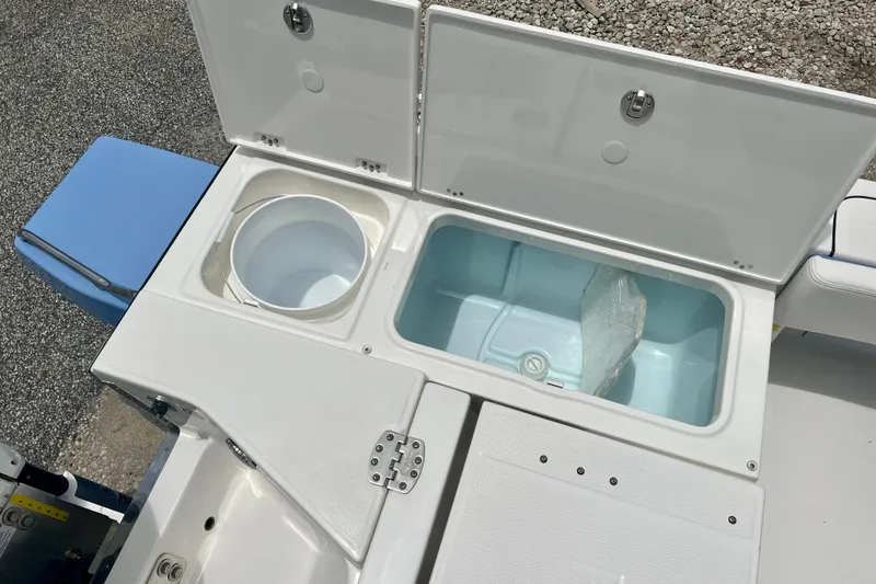 Slide: The Image of 2025 Robalo 266 Cayman SD boat storage compartments with open lids. - 12