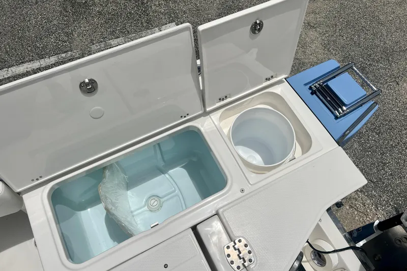 Slide: The Image of 2025 Robalo 266 Cayman SD boat storage compartments and seating area. - 13