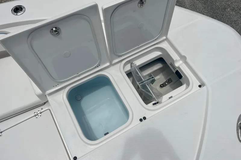 Slide: The Image of 2025 Robalo 266 Cayman SD boat storage compartments open on deck. - 16