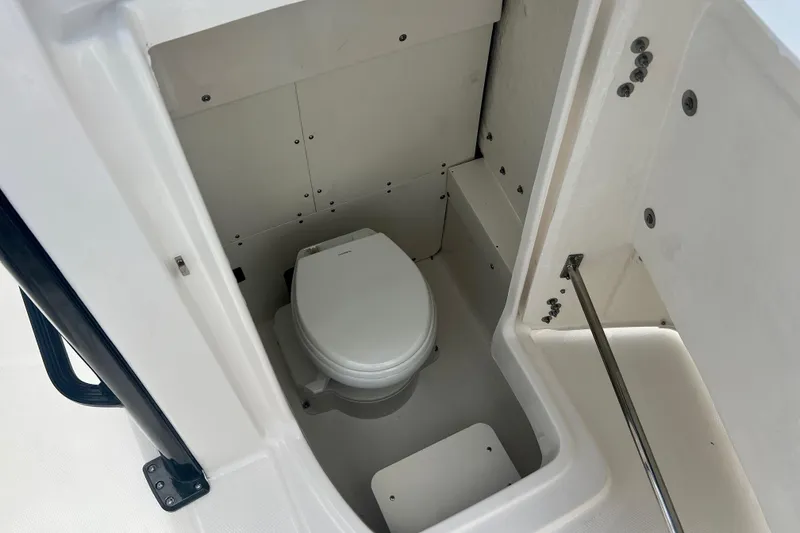 Slide: The Image of 2025 Robalo 266 Cayman SD boat interior with compact marine toilet. - 23