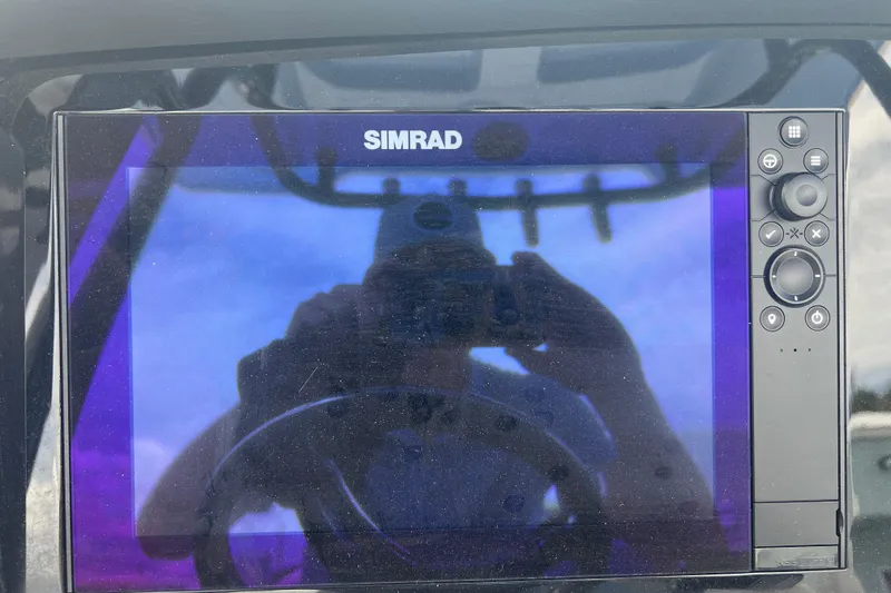 Slide: The Image of Simrad display on 2025 Robalo 266 Cayman SD boat dashboard, reflecting a person. - 34