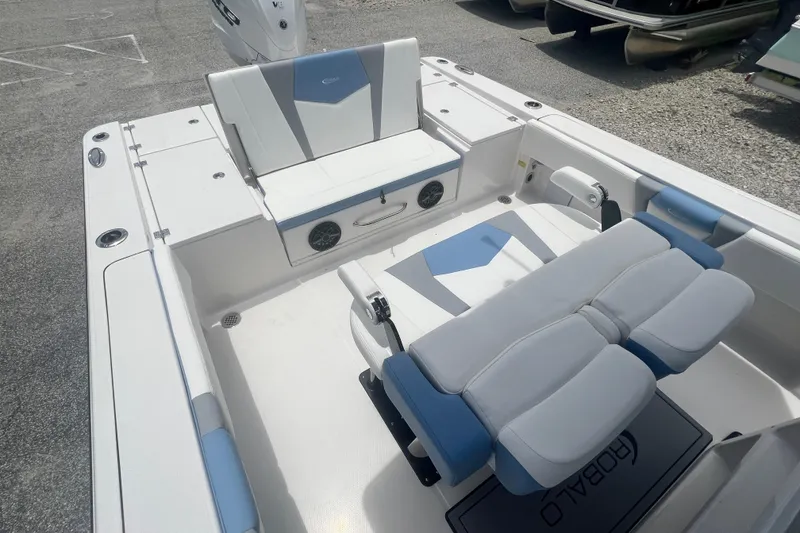 Slide: The Image of 2025 Robalo 266 Cayman SD boat interior with cushioned seating and storage compartments. - 9
