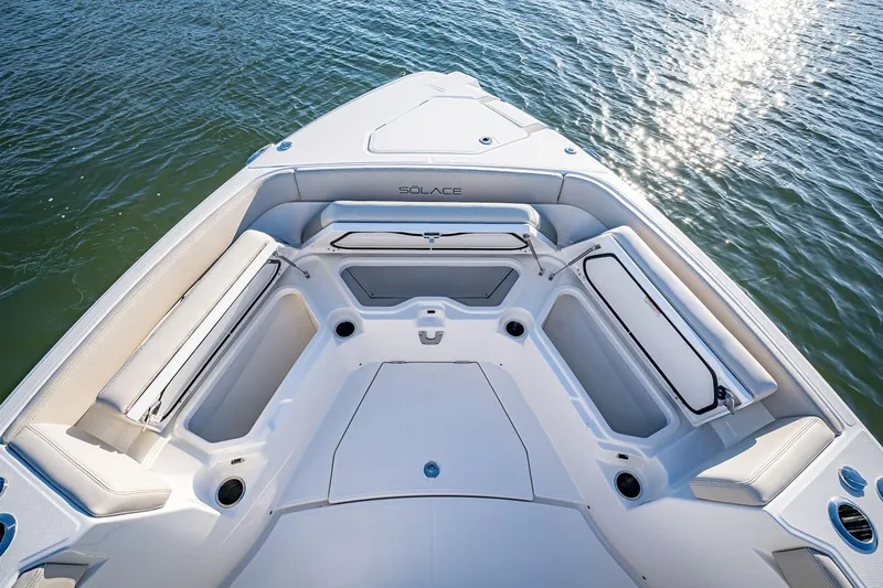 Slide: The Image of Manufacturer Provided Image: 2026 Solace 30 CS boat interior with cushioned seating, on calm water. - 3