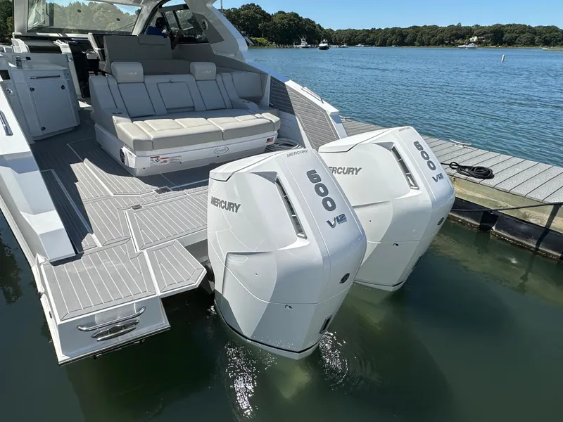 Slide: The Image of 2024 Cruisers Yachts 42 GLS Outboard with twin Mercury 600 V12 engines docked by a lake. - 10